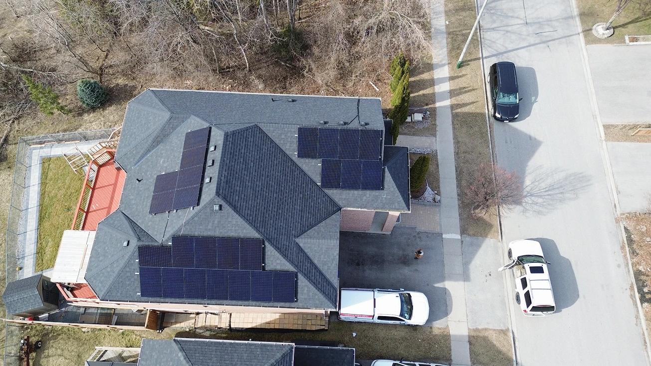 Aerial view of an Ontario home with a high-performance residential solar and battery system, featuring sleek black panels and $14,000 in available rebates.