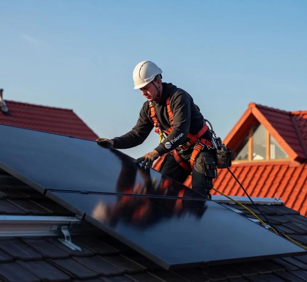 Solar installer working on rooftop solar panels.
