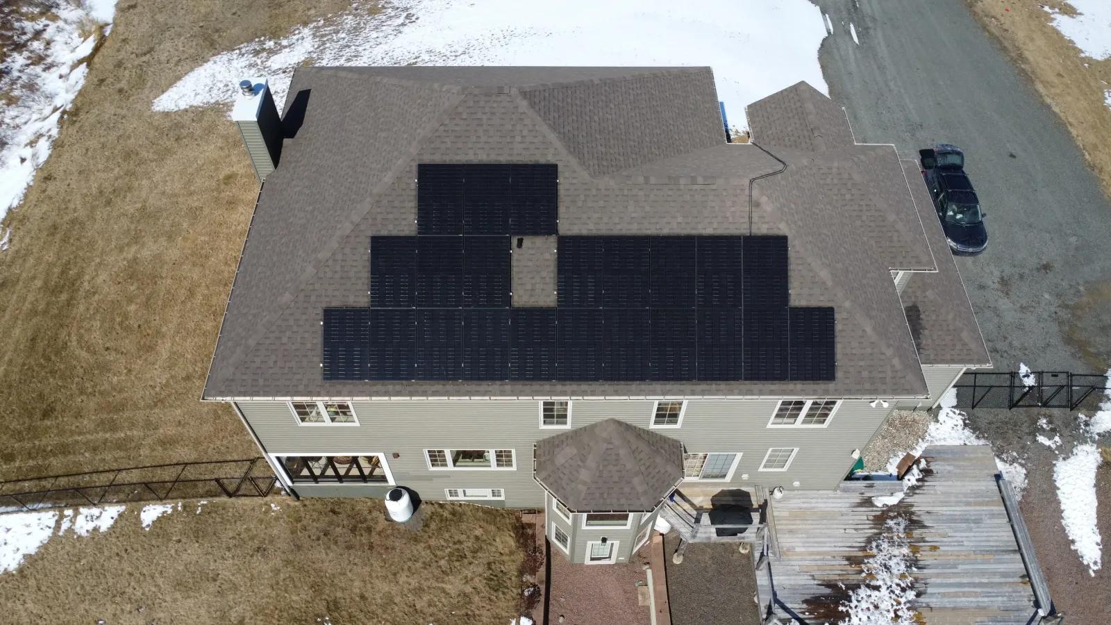 Aerial view of a Grand-Barachois, New Brunswick home with a large black solar array covering the main roof.