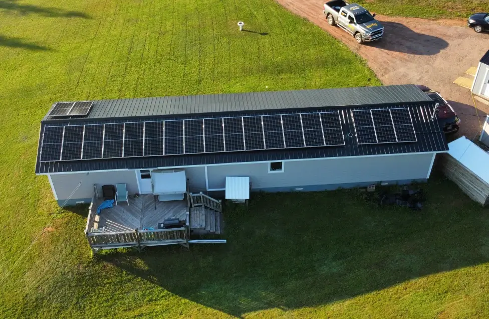 Aerial view of a high-capacity residential solar array on a long PEI roof, demonstrating a professional installation designed to maximize Maritime Electric net metering credits.